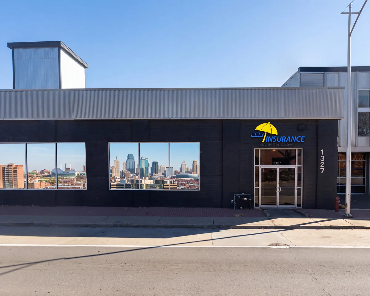 The BBS Insurance storefront at 1327 Burlington St, North Kansas City, with the downtown Kansas City skyline reflected in its windows